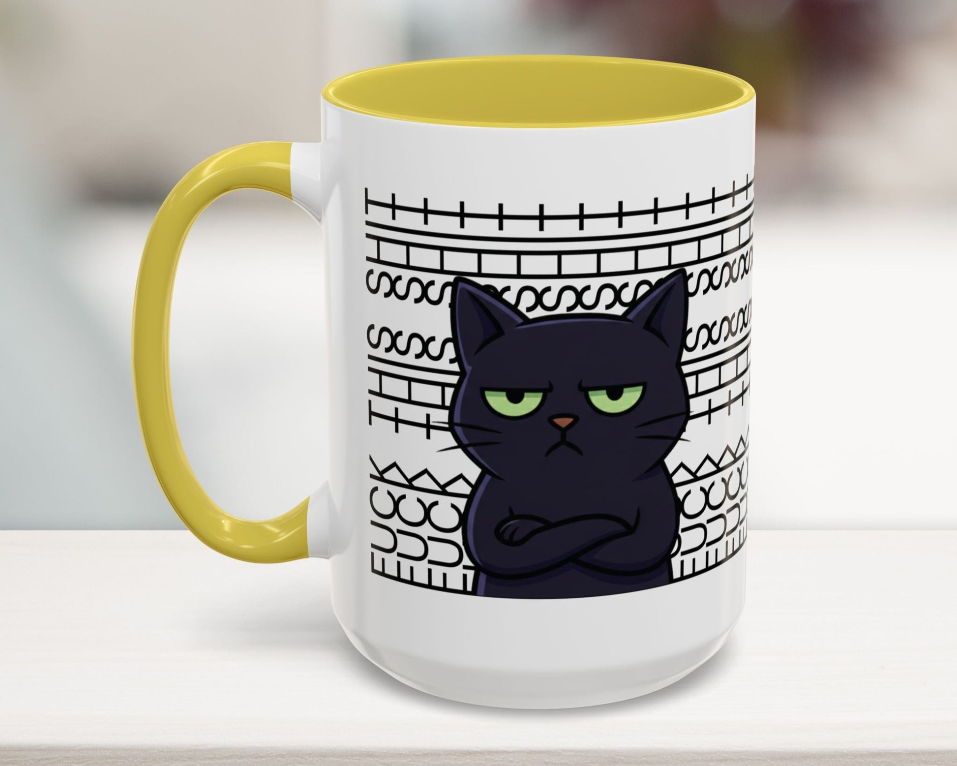 Mug with a black cat design and yellow handle on a white surface