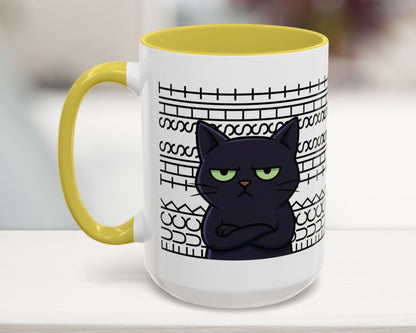 Mug with a black cat design and yellow handle on a white surface