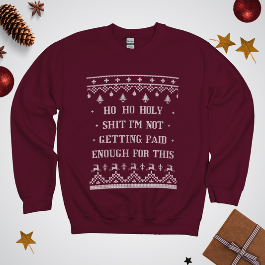 Maroon sweatshirt with Christmas-themed text and graphics on a white background with festive decorations.