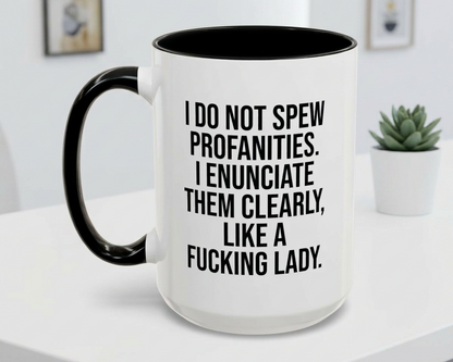White mug with black interior and handle, featuring text on a white surface with a plant in the background.