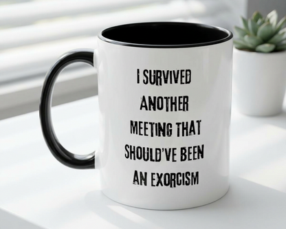 White mug with black interior and handle, featuring text on a white surface with a plant in the background.