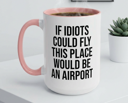 White mug with pink handle and humorous text on a white surface with a plant in the background