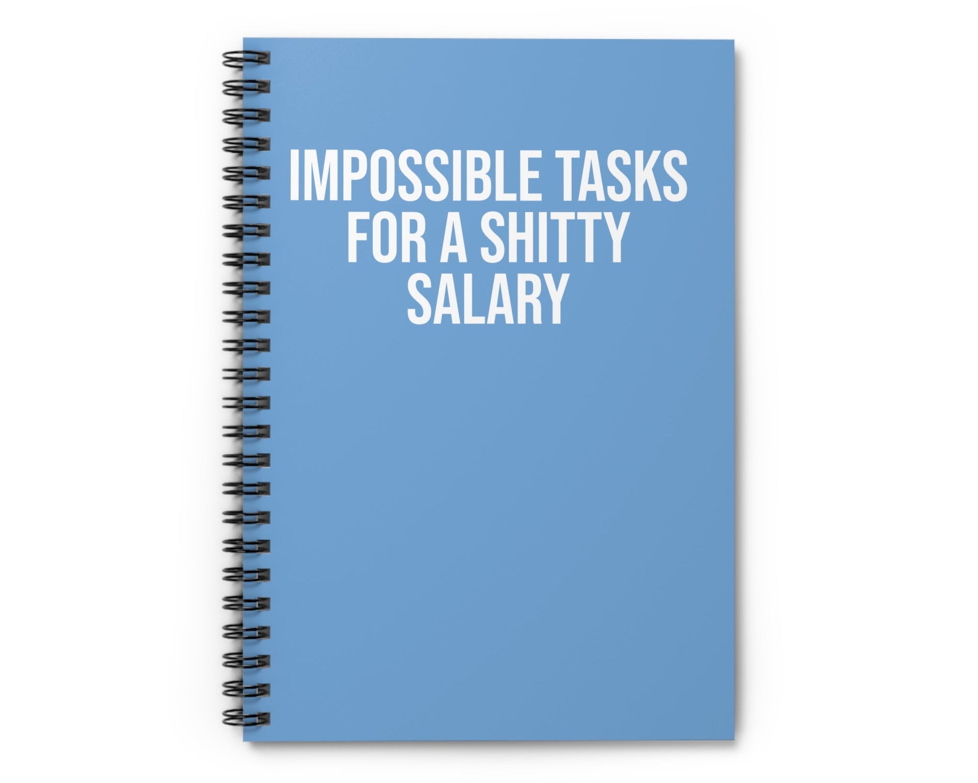 Blue notebook with text 'IMPOSSIBLE TASKS FOR A SHITTY SALARY' on a white background