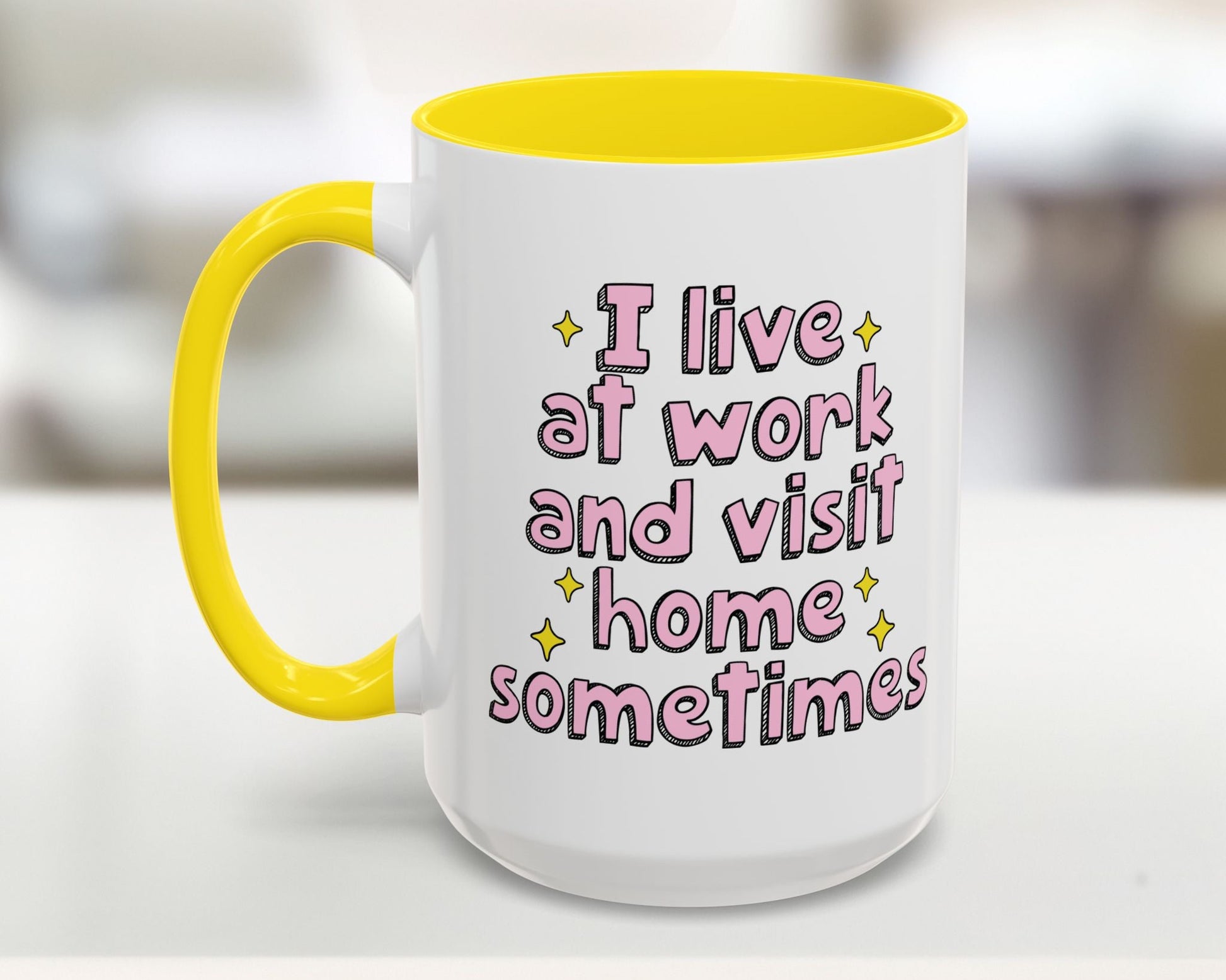White mug with yellow interior and handle, featuring pink text on a blurred background