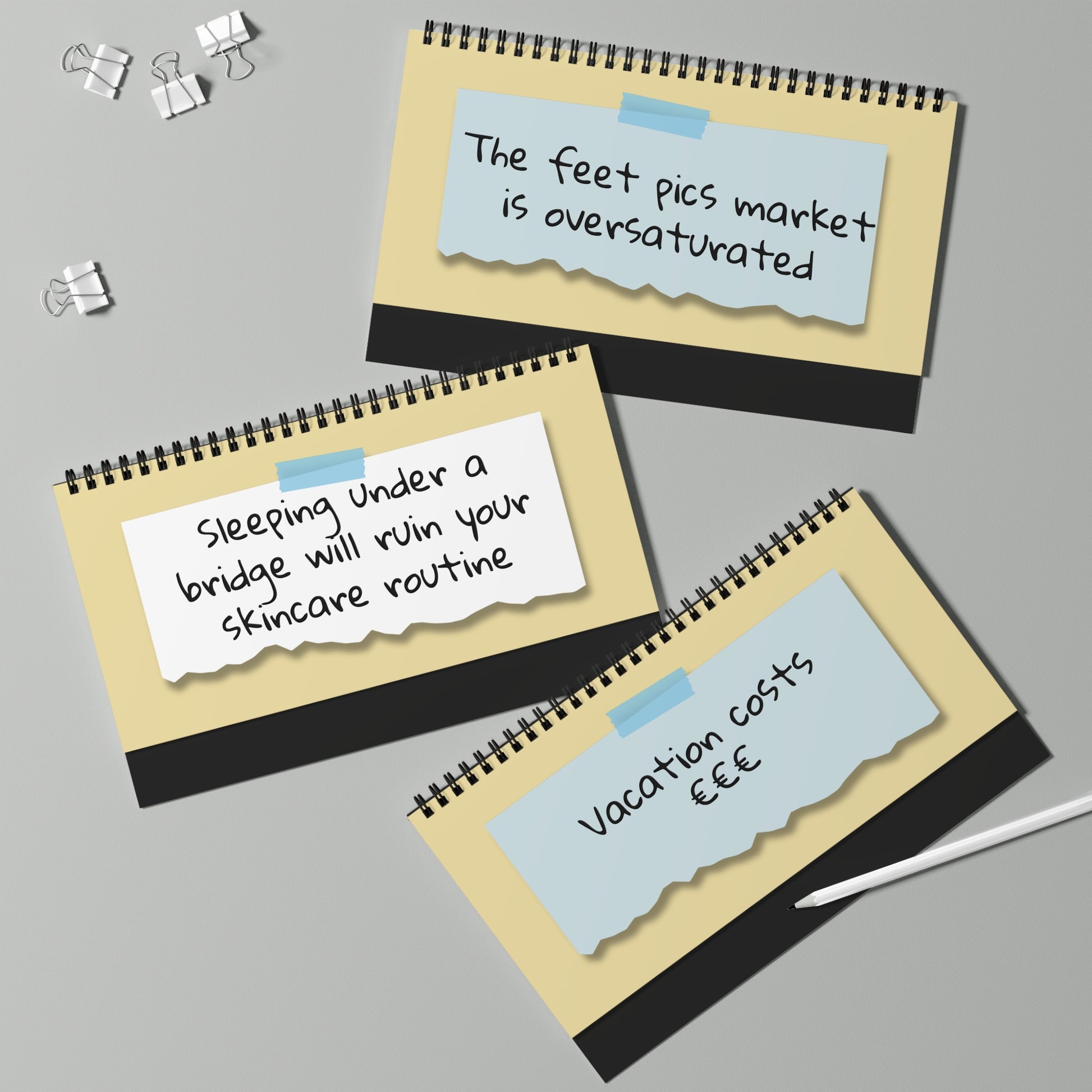 Three spiral-bound notebooks with humorous text on a gray background