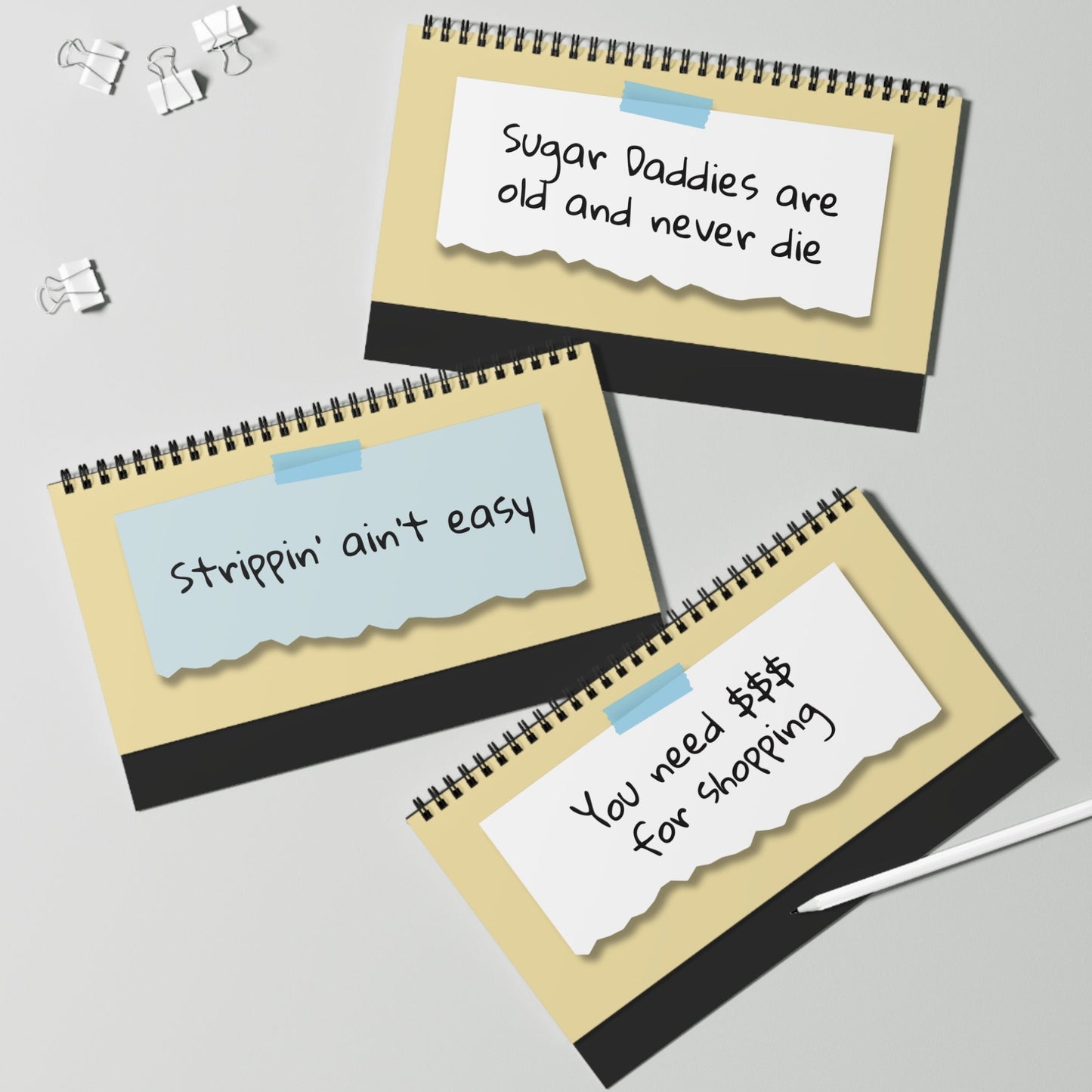 Three spiral-bound notebooks with text on a gray background