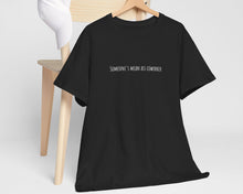 Black t-shirt with print on a wooden hanger against a white background