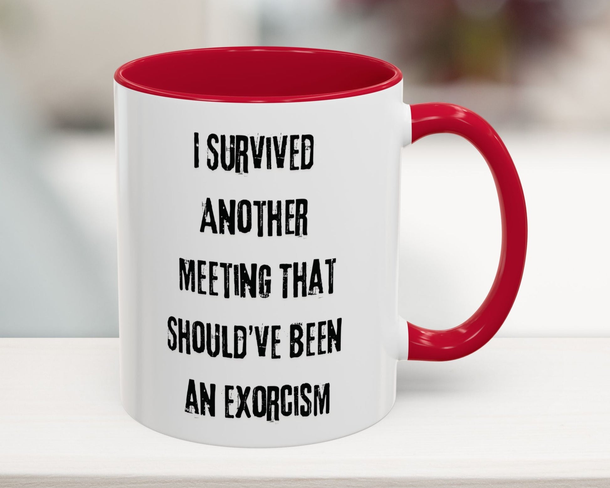 White mug with red interior and handle featuring humorous text on a blurred background