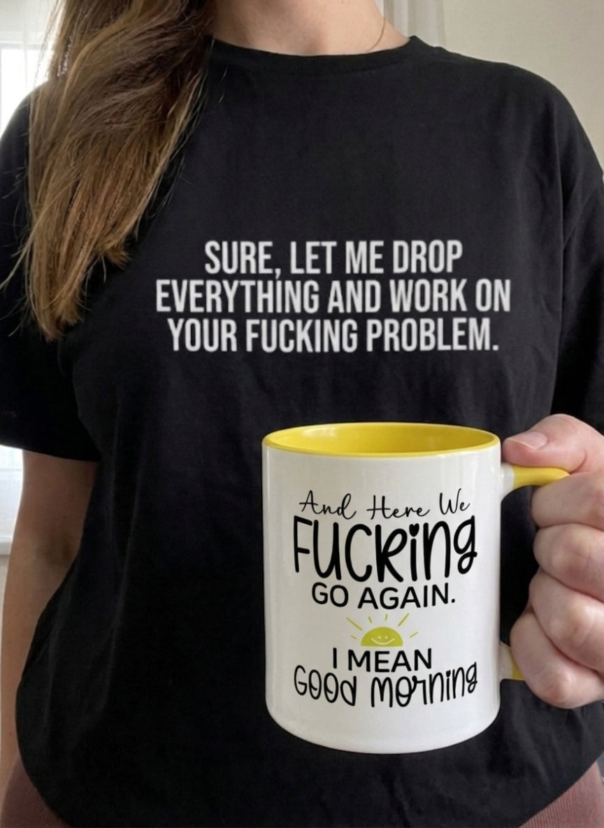 Person wearing a black t-shirt with bold text and holding a white mug with yellow interior.