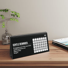 Desk calendar with humorous message on a wooden surface