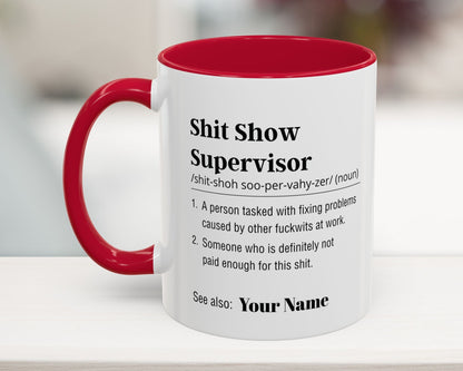 Mug with red interior and handle, featuring humorous definition text on a blurred background