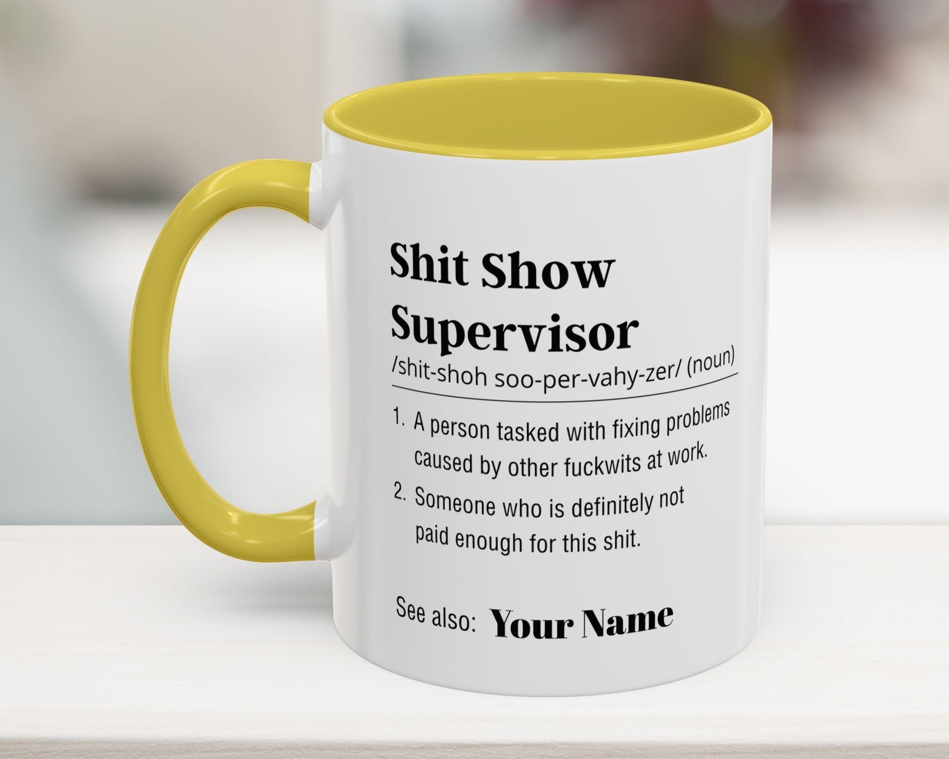 Mug with yellow interior and handle, featuring text on a blurred background