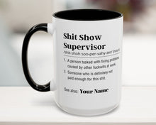 Mug with text definition of 'Shit Show Supervisor' on a blurred background