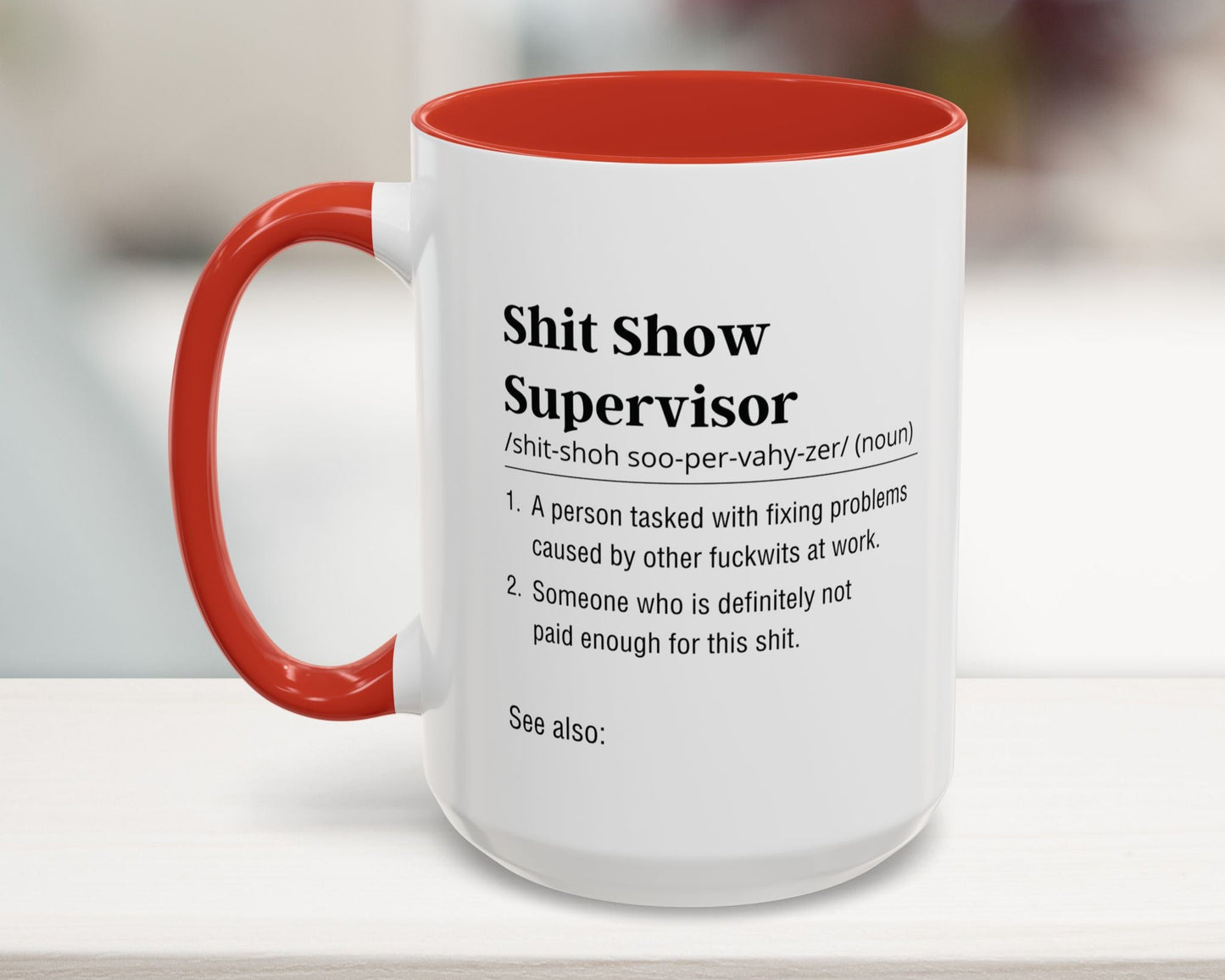 Mug with red interior and handle featuring text definition on a blurred background