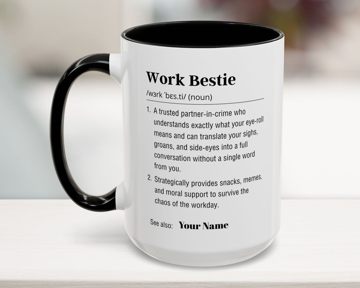 Mug with text definition of 'Work Bestie' on a blurred background