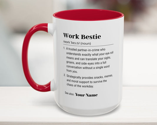 White mug with red interior and handle featuring a definition of 'Work Bestie' on a blurred background