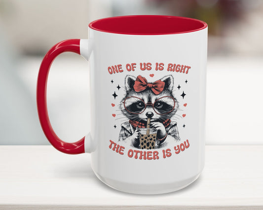 Mug with a raccoon illustration and text on a white surface