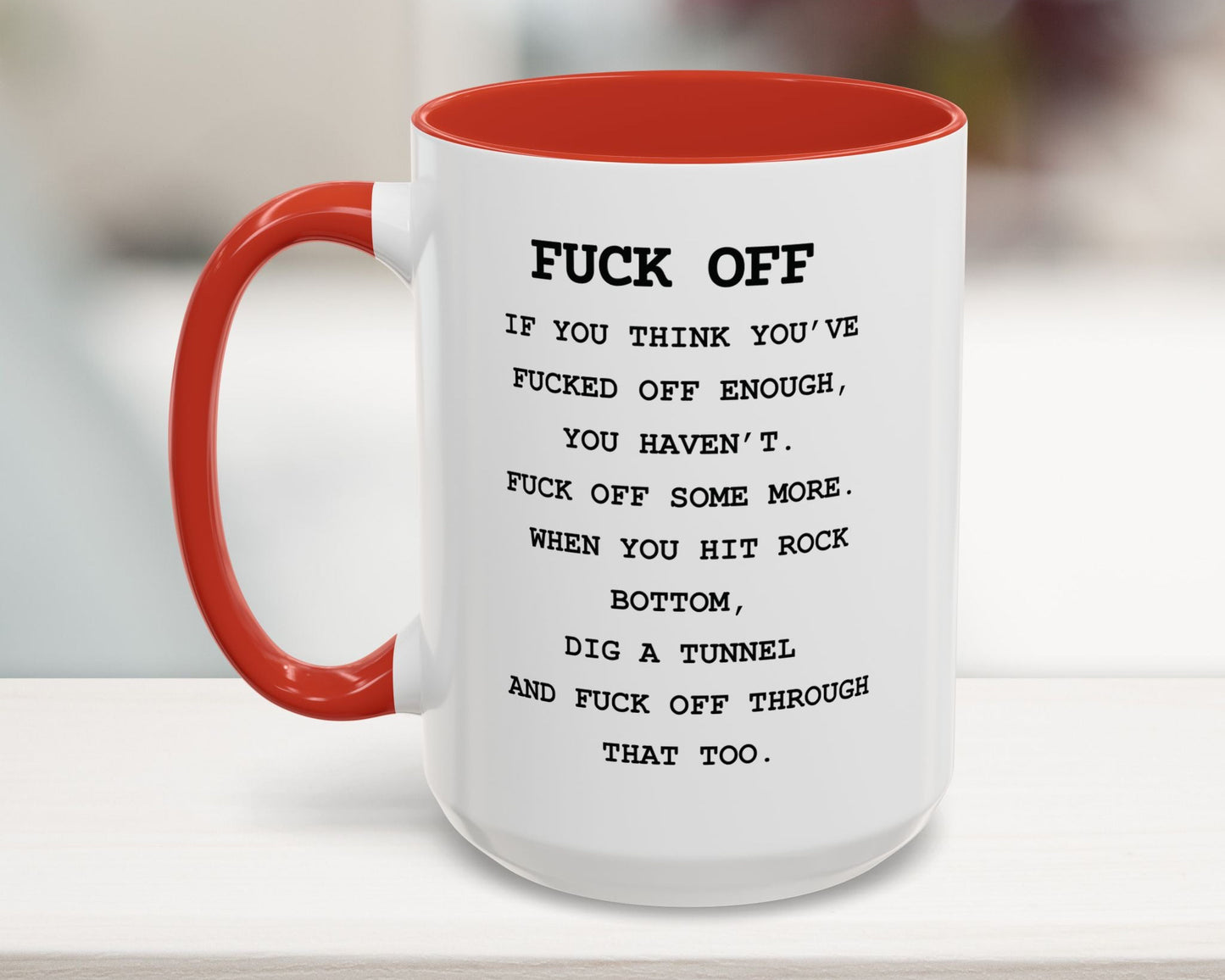 Mug with red interior and handle, featuring a message on a blurred background