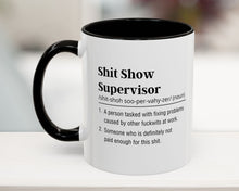 Mug with text definition of 'Shit Show Supervisor' on a blurred background