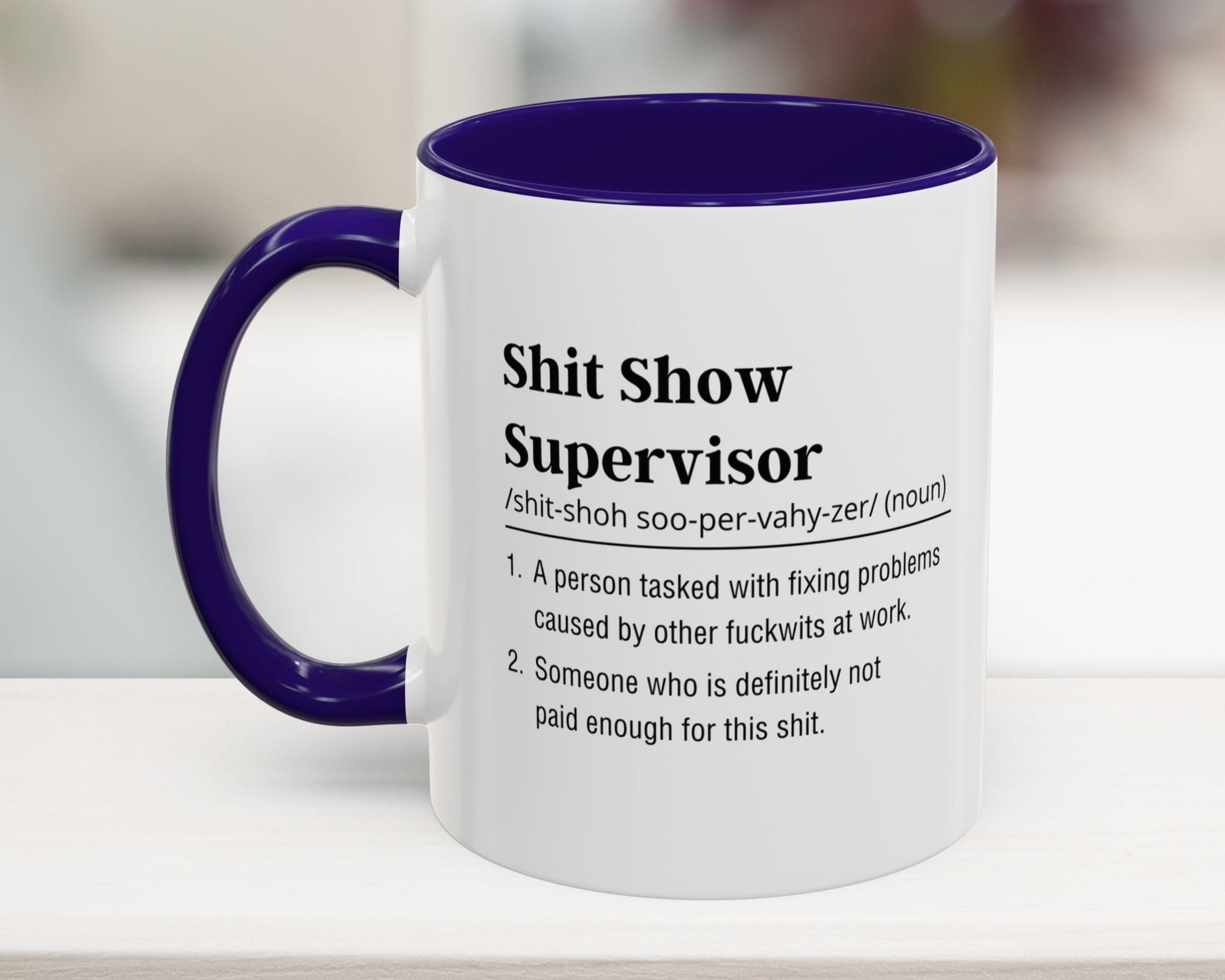 Mug with purple handle and interior, featuring text on a blurred background