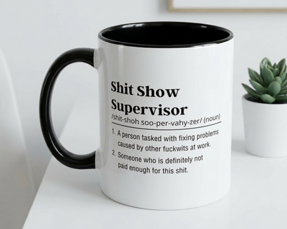 Mug with text on a white surface with a plant in the background