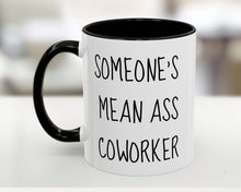 Mug with text 'SOMEONE'S MEAN ASS COWORKER' on a blurred background