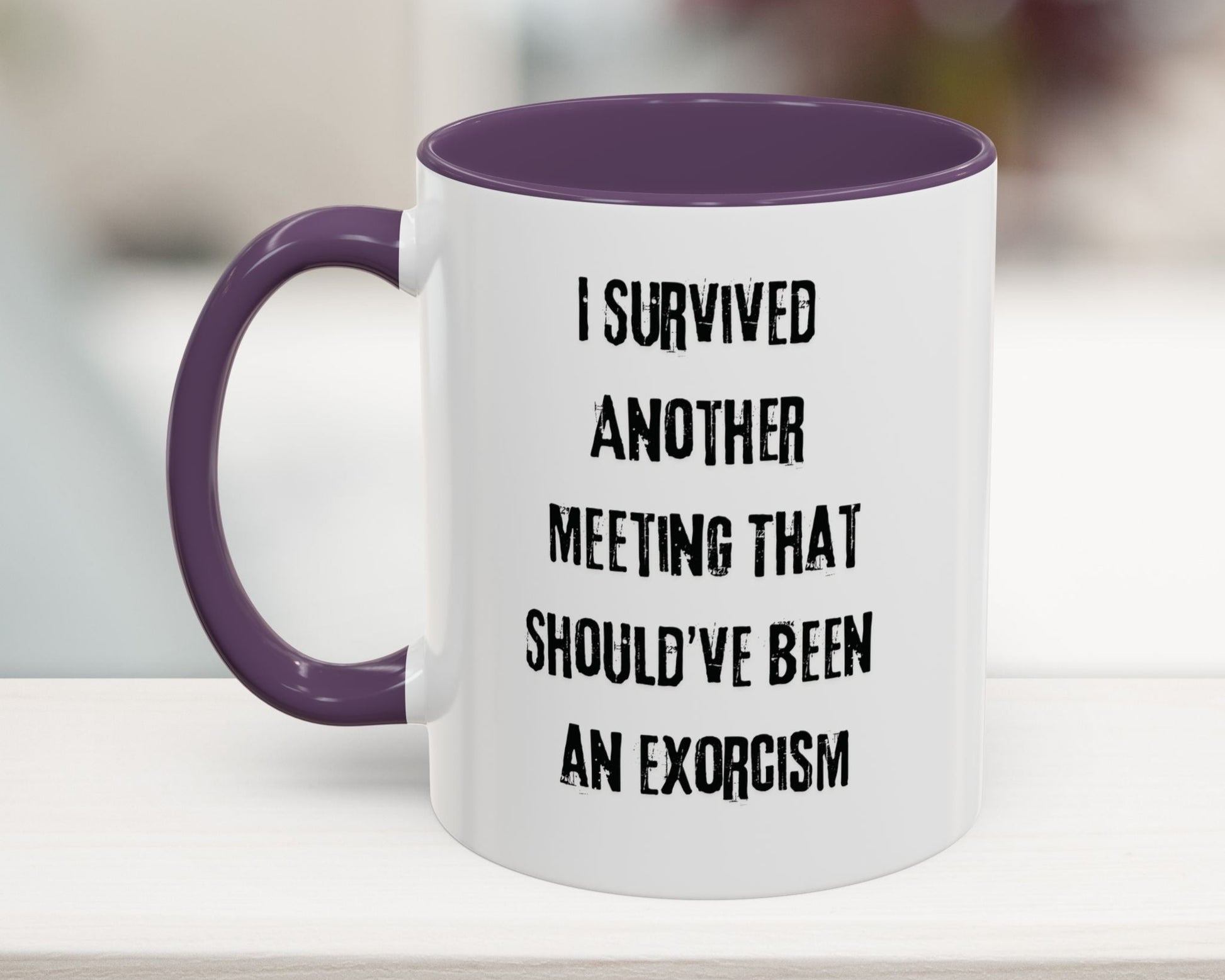 White mug with purple handle and interior, featuring text on a blurred background