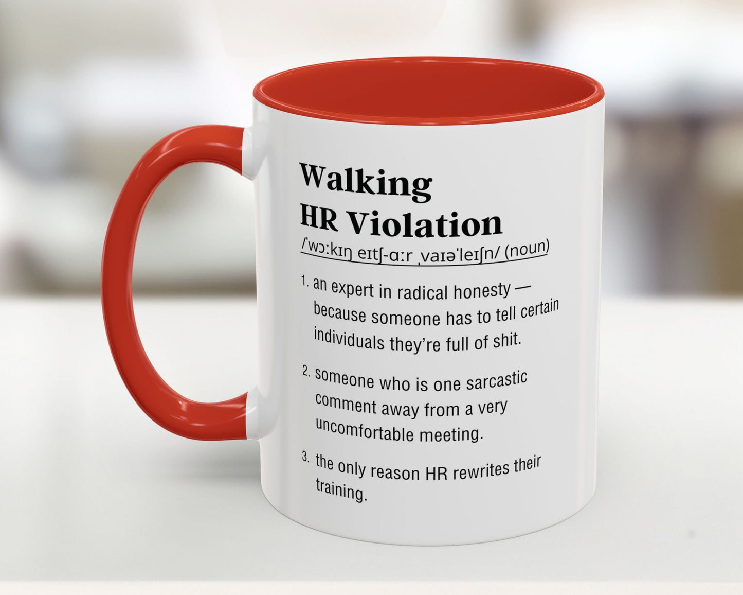 Mug with red interior and handle featuring humorous definition text on a blurred background
