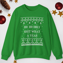 Green sweater with Christmas-themed text and patterns on a white background with festive decorations.