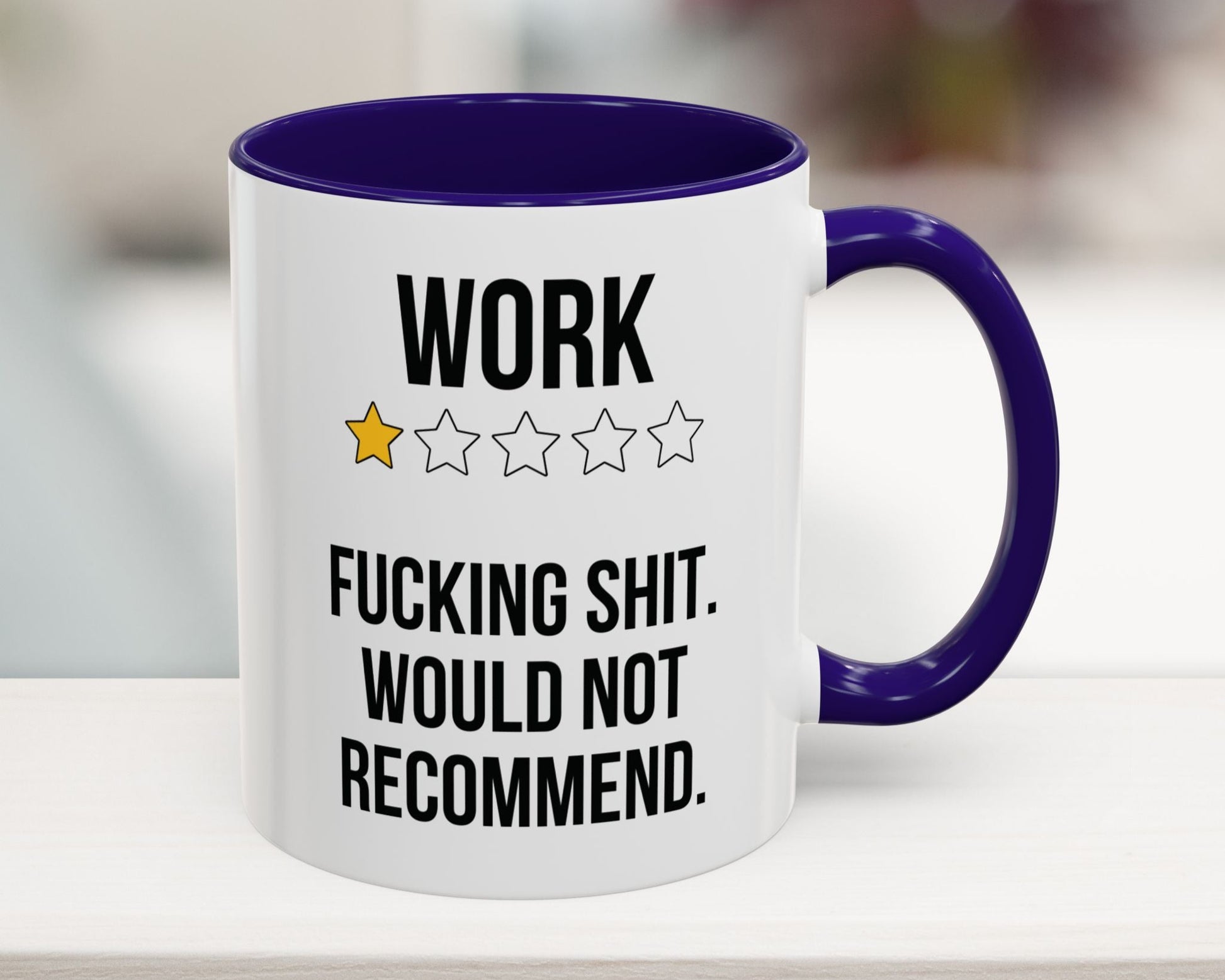 Mug with text 'WORK ★★★★ F***ING SHIT. WOULD NOT RECOMMEND.' and purple interior and handle on a blurred background