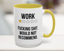 Mug with text 'WORK F***ING SHIT. WOULD NOT RECOMMEND.' and yellow handle on a blurred background